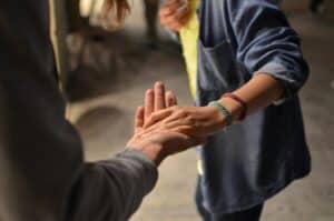 Two people offering support with a helping hand in a mental health awareness setting.